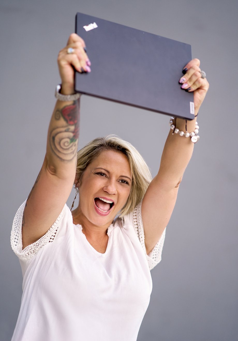 angelika-stempfle-hero-website-als-beste-mitarbeiterin Angelika Stempfle hält jubelnd ihren Laptop über den Kopf