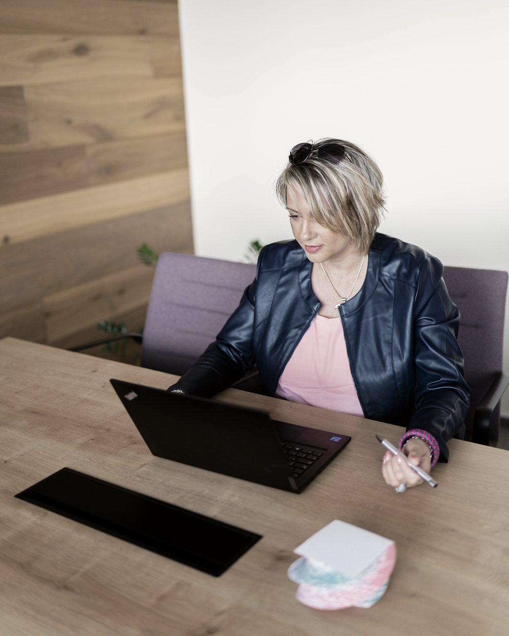 Angelika Stempfle sitzt am Schreibtisch vor dem Laptop und schaut konzentriert auf den Bildschirm